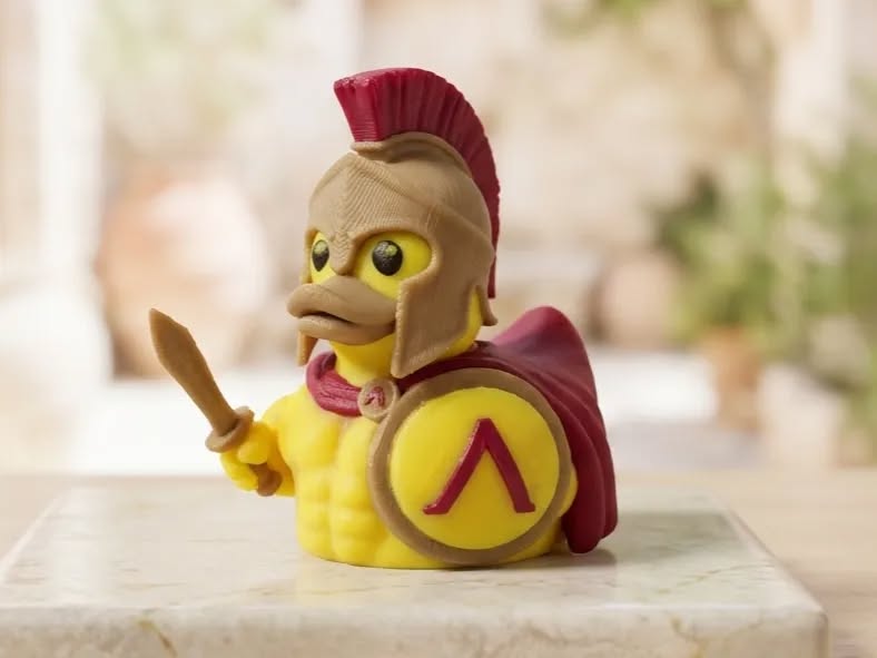 3D printed Spartan warrior duck with red-crested helmet, crimson cape, spear, and lambda shield